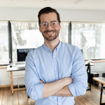 Smiling workshop attendee with his arms crossed in a blue button-down shirt